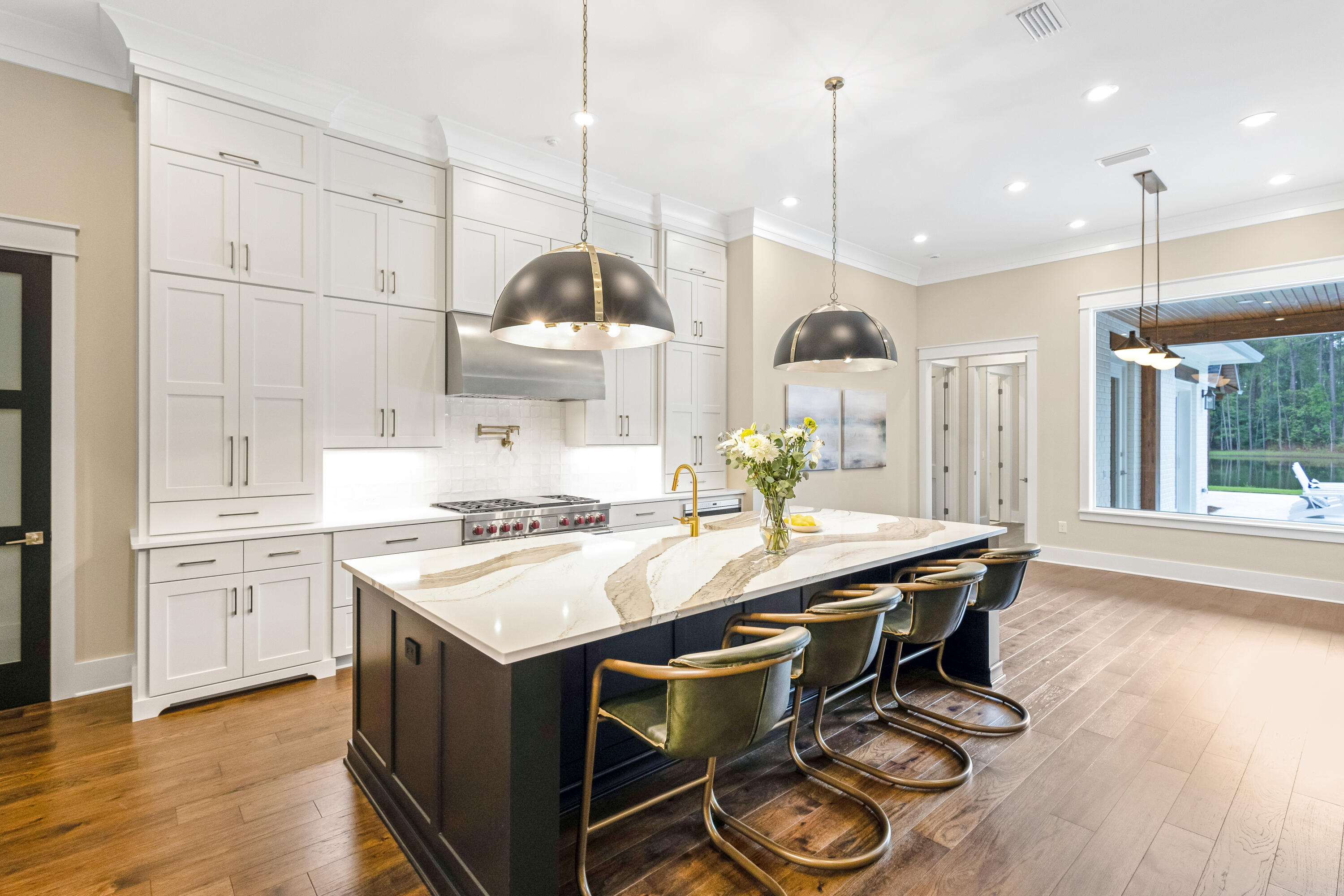 71 Clermont Cove Freeport, FL 32439 - Photo 12 of 73 a kitchen with stainless steel appliances granite countertop a stove a sink dishwasher a dining table and chairs with wooden floor