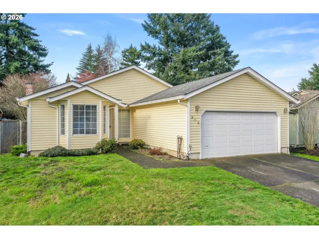 a front view of a house with a garden and yard