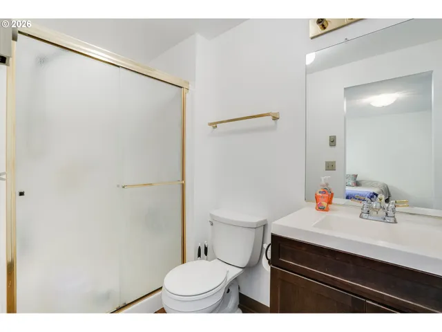 a bathroom with a sink toilet vanity and shower