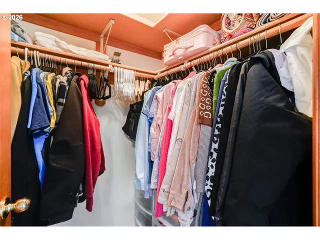 a view of walk in closet with clothes
