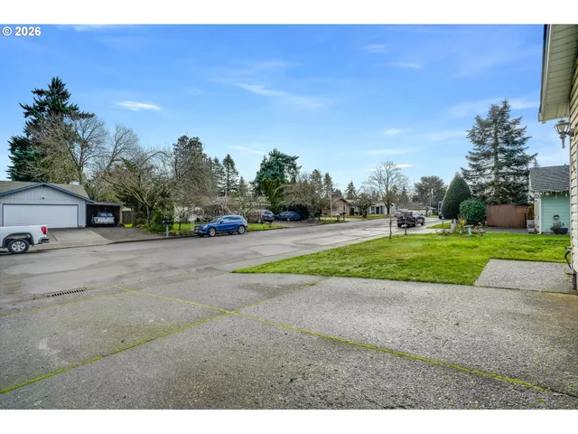 a view of road with house and trees in the background