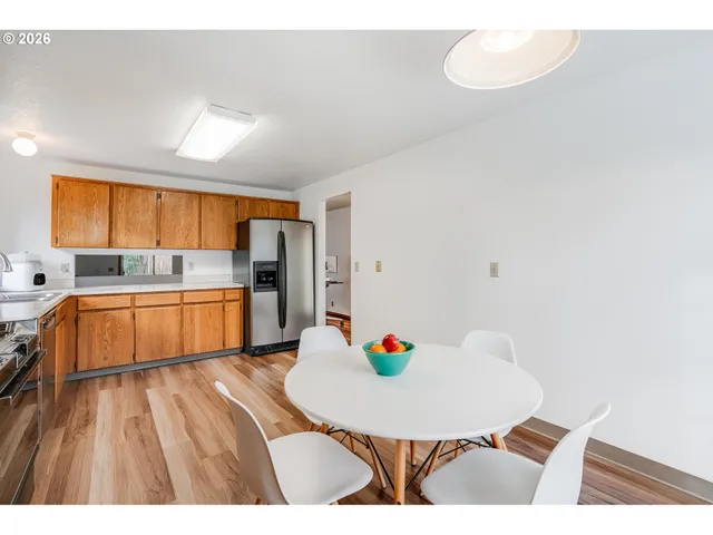 a kitchen with stainless steel appliances kitchen island granite countertop a sink a microwave a dining table and chairs