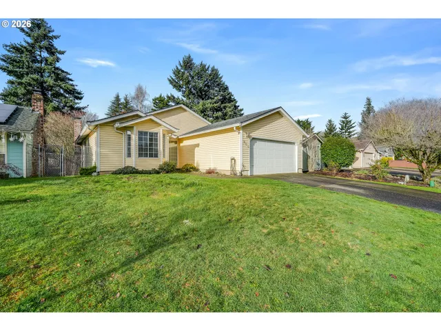 a view of a yard in front of a house with large trees