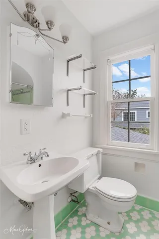 a bathroom with a sink a toilet and a mirror
