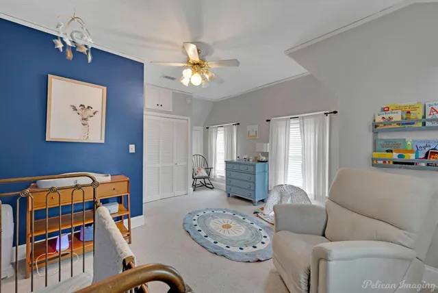 a living room with furniture a baby crib and a book shelf