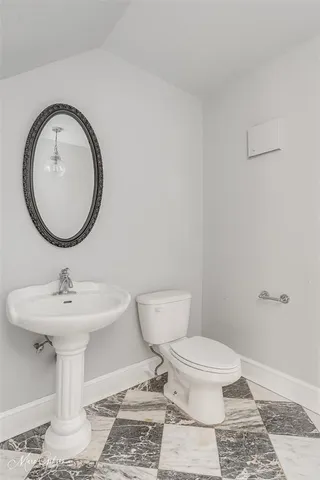 a bathroom with a toilet a sink and a mirror