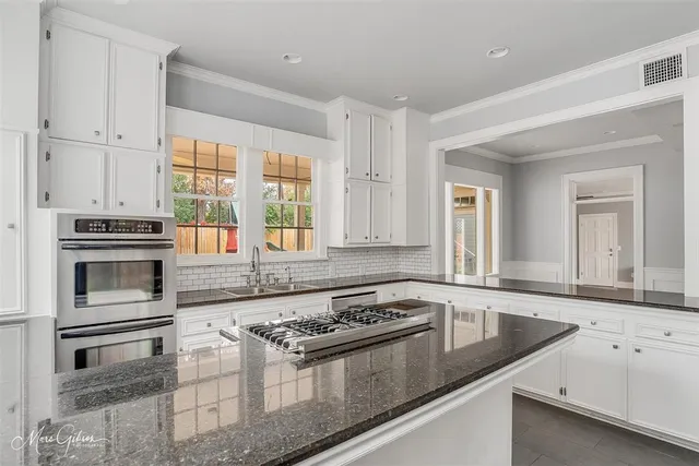 a kitchen with granite countertop a stove sink and cabinets
