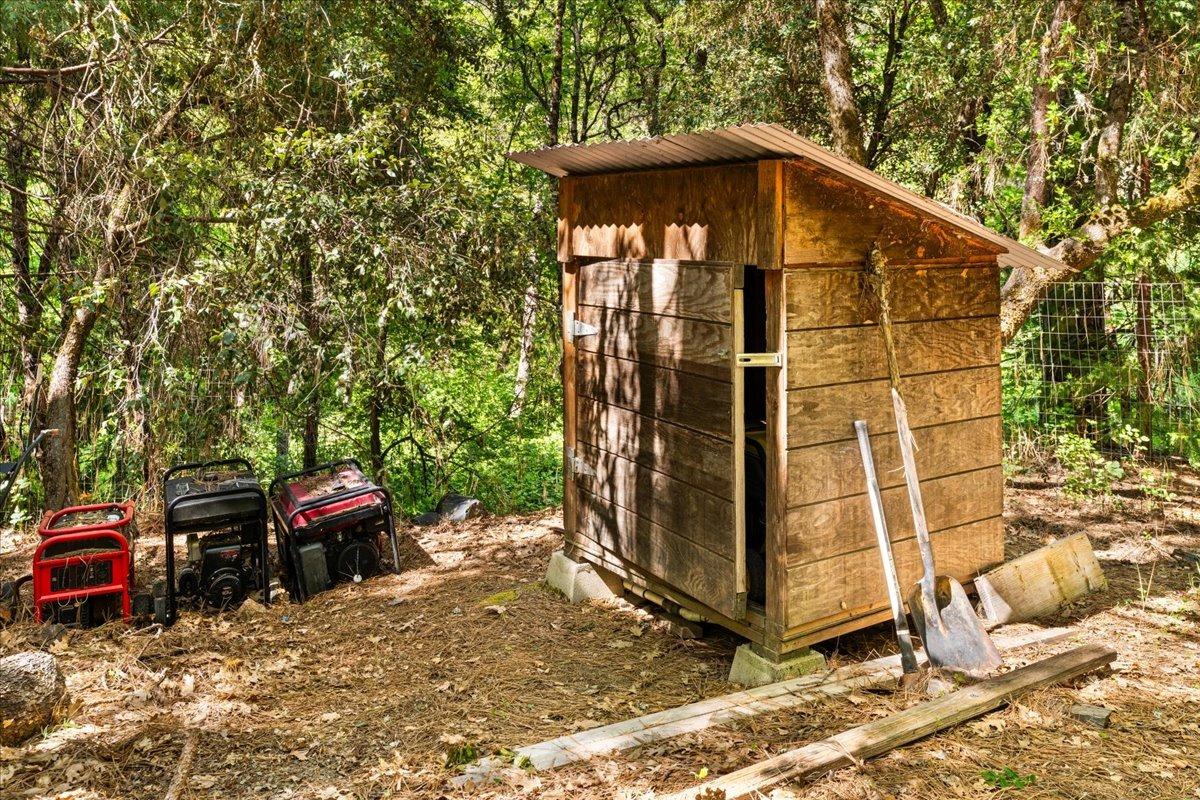 12921 Slate Creek Road Nevada City, CA 95959 - Photo 16 of 41 a view of a wooden house with a small yard and large trees