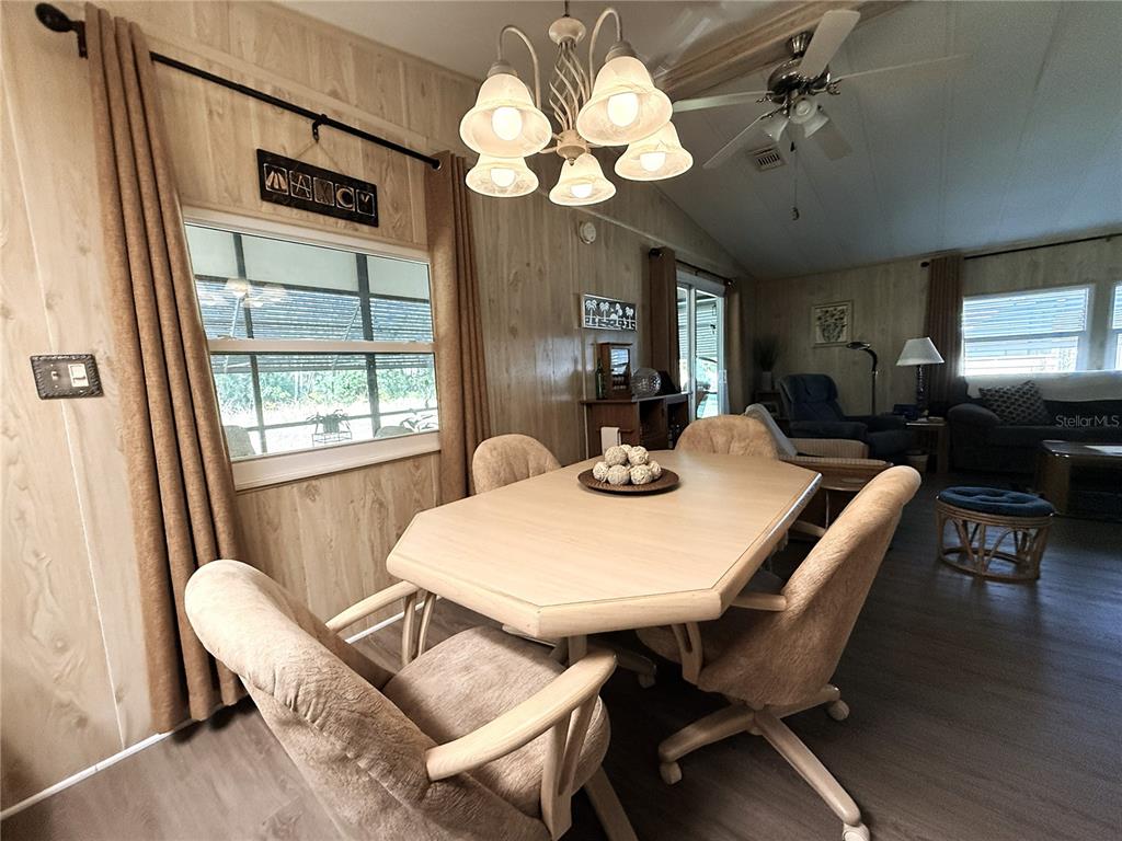 4418 Brave Lane St. Cloud, FL 34772 - Photo 12 of 29 a view of a dining room with furniture a chandelier and wooden floor