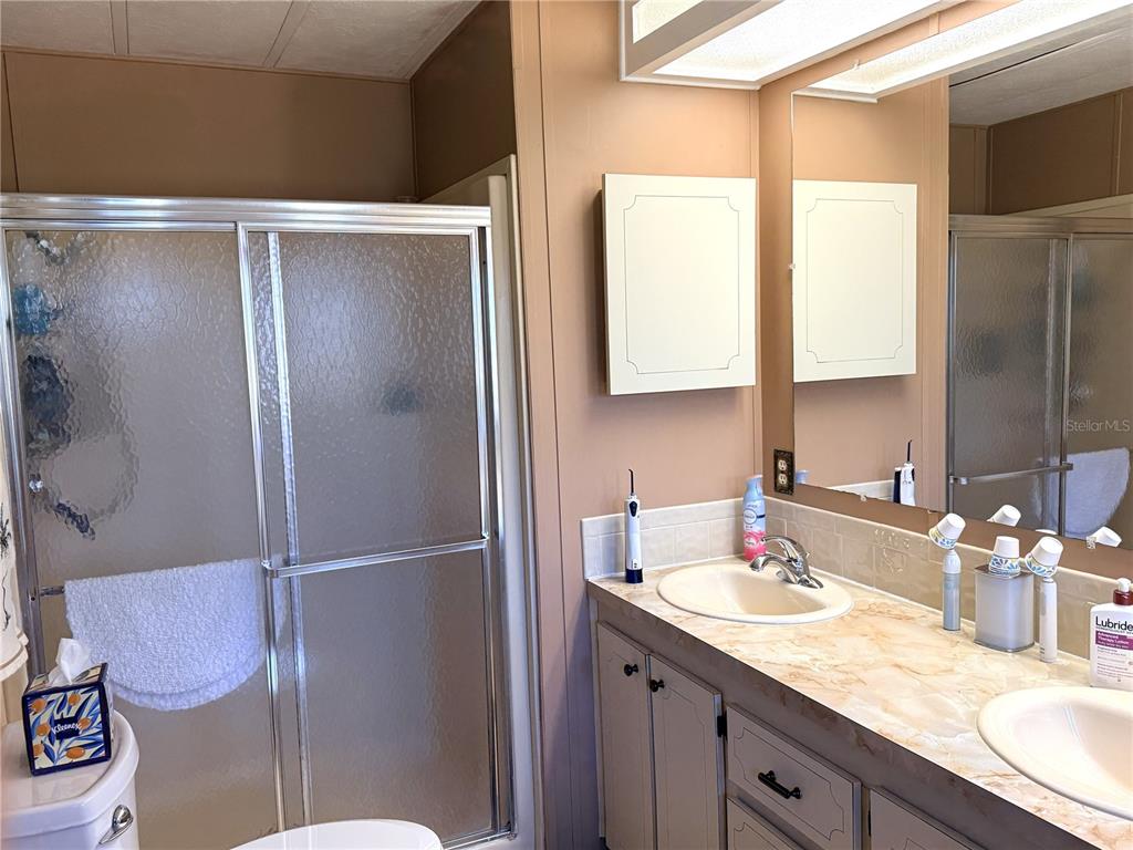 4418 Brave Lane St. Cloud, FL 34772 - Photo 19 of 29 a bathroom with a granite countertop sink mirror and toilet