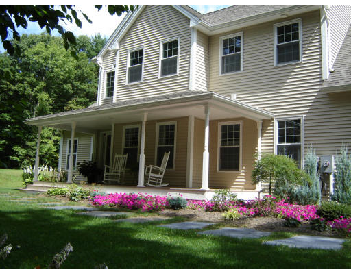 a front view of a house with a big yard and potted plants