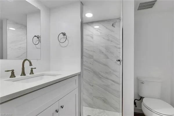 a bathroom with a sink a toilet and shower