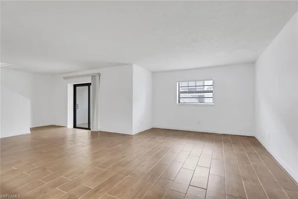 a view of empty room with wooden floor and windows