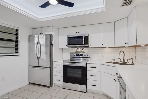 a kitchen with cabinets stainless steel appliances and a counter space