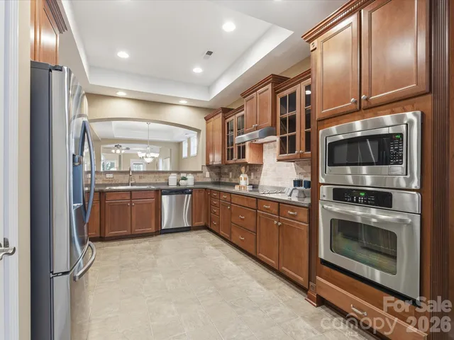 a kitchen with stainless steel appliances granite countertop a stove a sink and a refrigerator