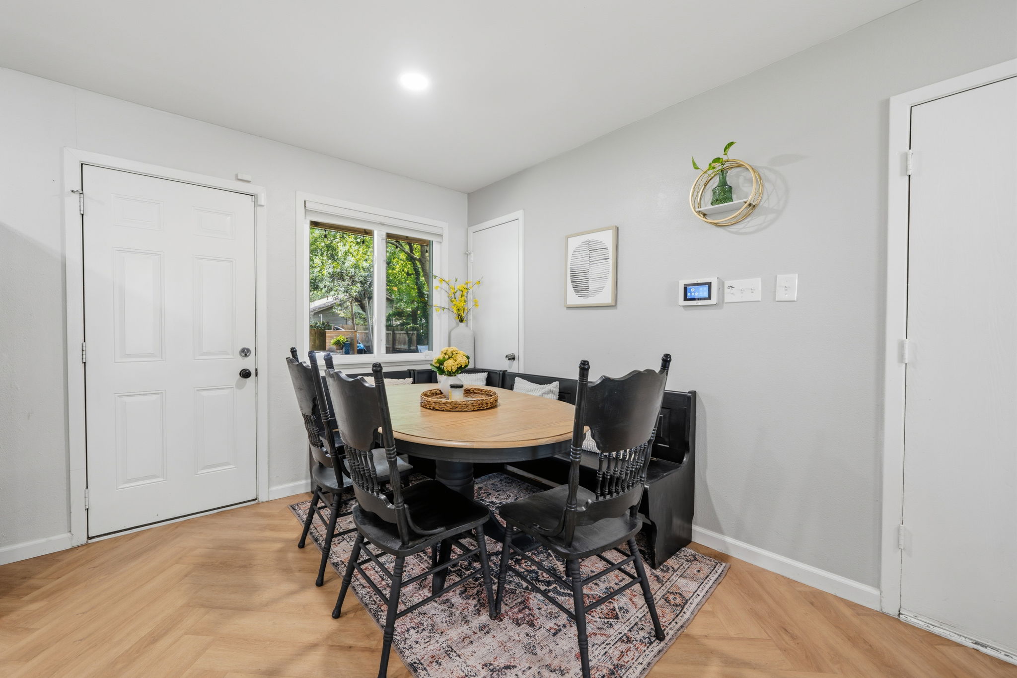 705 Dulwich Street Austin, TX 78748 - Photo 6 of 36 Herringbone wood flooring and a bright window elevate the comfort and function of this dining area.