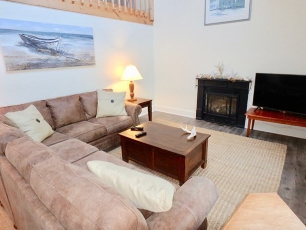 54 Schoolhouse Road Edgartown, MA 02539 - Photo 4 of 30 a living room with furniture a flat screen tv and a fireplace