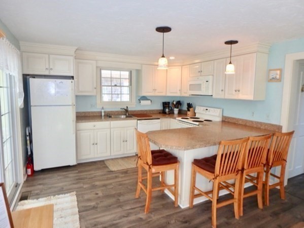 54 Schoolhouse Road Edgartown, MA 02539 - Photo 6 of 30 a kitchen with stainless steel appliances granite countertop a sink a stove a refrigerator and island with wooden floor