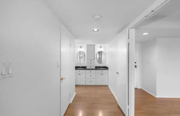 a bathroom with a granite countertop double vanity sink and a mirror