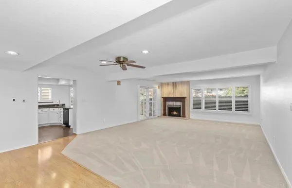 a view of an empty room with a fireplace and a window