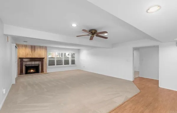 a view of an empty room with a fireplace and a window