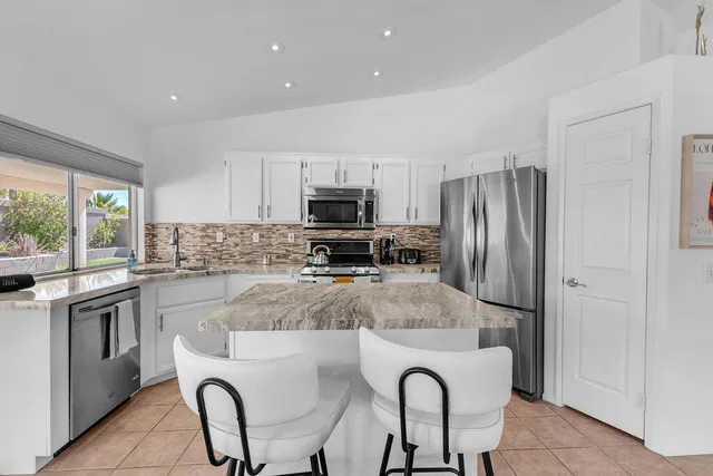 a kitchen with refrigerator cabinets and chair