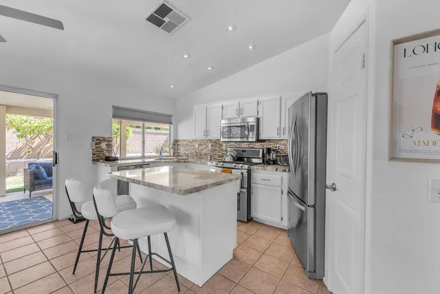 a kitchen with appliances a sink and a window