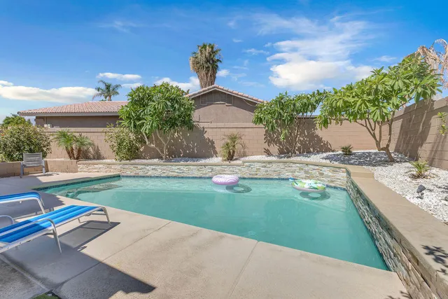 a view of backyard with swimming pool and outdoor seating