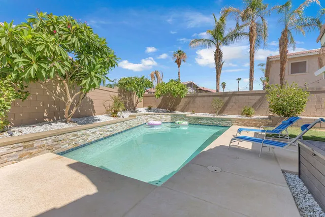 a swimming pool with outdoor seating and yard