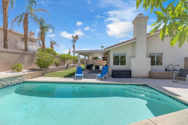 a view of a house with backyard and sitting area