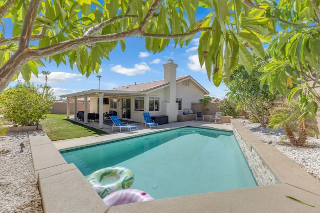 a view of a patio with table and chairs potted plants with floor to ceiling window