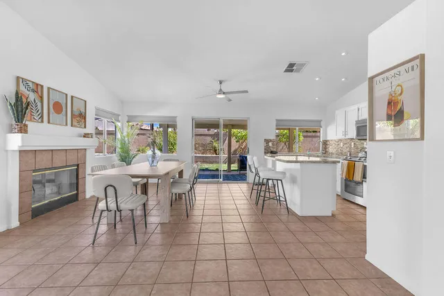 a living room with furniture a fireplace and a kitchen view