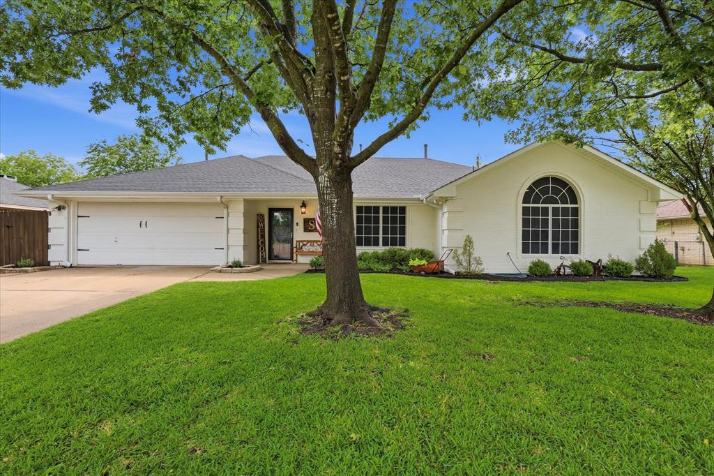 202 Colonial Heights Sanger, TX 76266 - Photo 2 of 27 a view of a yard in front of a house with plants and large tree