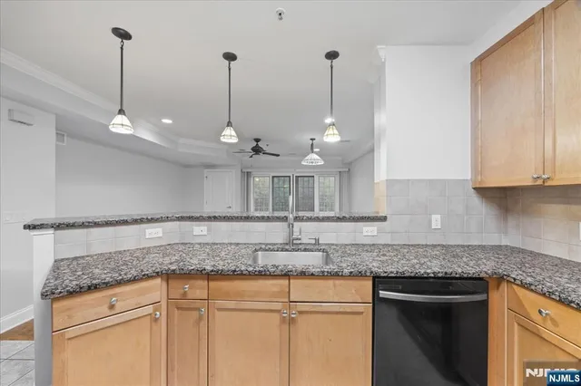 a kitchen with stainless steel appliances granite countertop a sink a refrigerator and a granite counter tops
