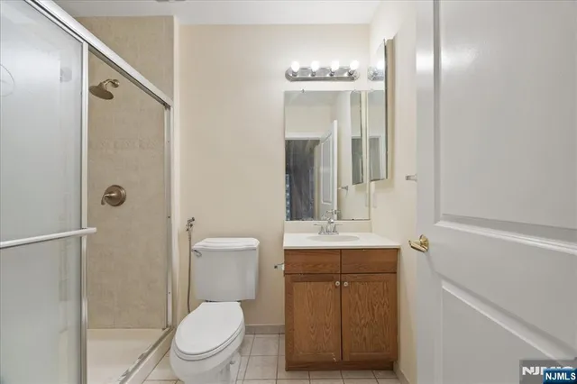 a bathroom with a toilet a sink a mirror and shower