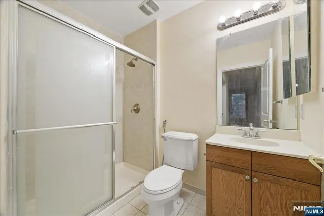 a bathroom with a toilet sink vanity and shower