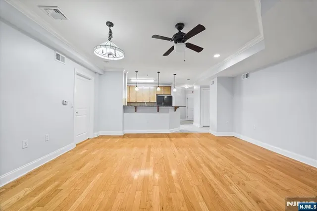 a view of empty room with wooden floor and window