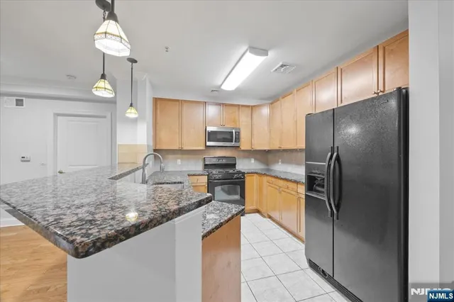 a kitchen with stainless steel appliances granite countertop a sink refrigerator and microwave