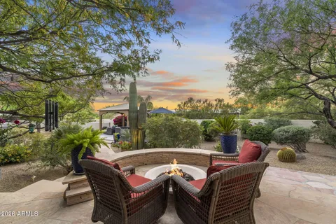 a view of a patio with a table and chairs potted plants