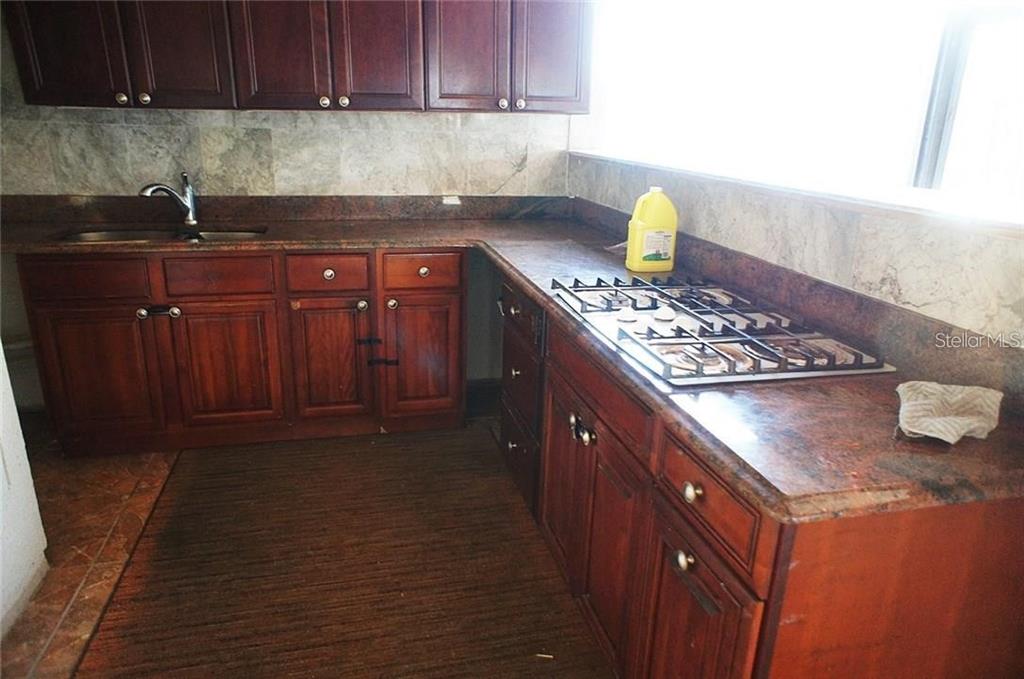 5948 Winchester Isle Road Orlando, FL 32829 - Photo 17 of 23 a kitchen with stainless steel appliances granite countertop a sink stove and cabinets