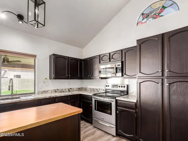 a kitchen with stainless steel appliances granite countertop a sink and a stove