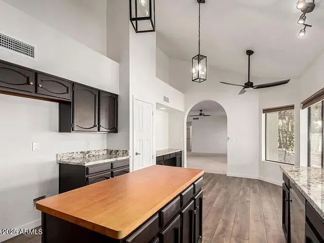 a kitchen with stainless steel appliances granite countertop a sink a stove and a refrigerator