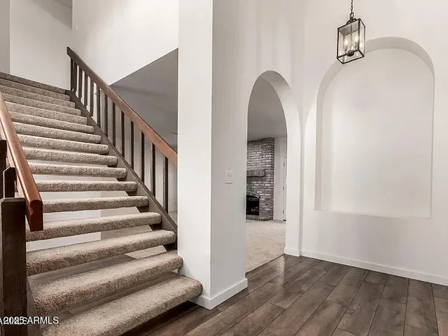a view of entryway and hall with wooden floor
