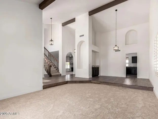 an empty room with fireplace and windows