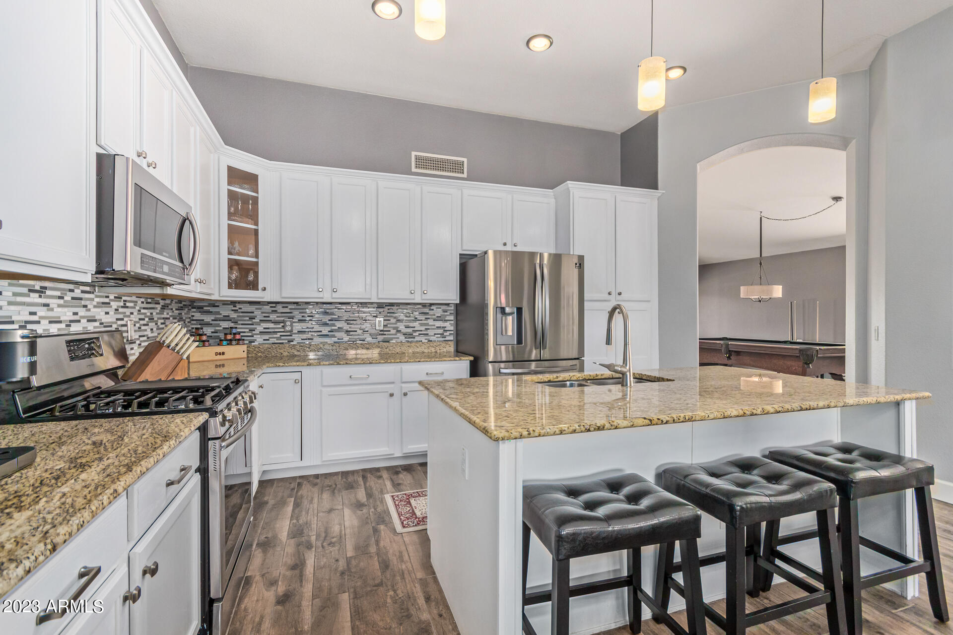 2065 South Marble Street Gilbert, AZ 85295 - Photo 13 of 59 a kitchen with kitchen island granite countertop a sink cabinets and stainless steel appliances