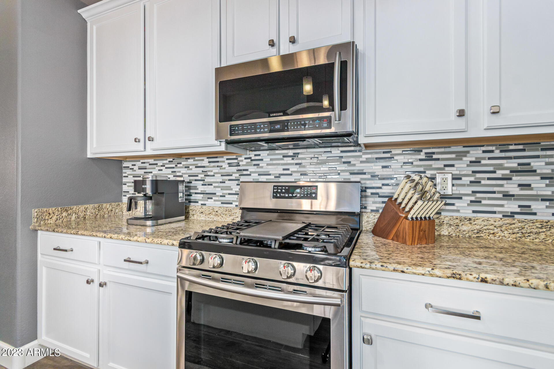 2065 South Marble Street Gilbert, AZ 85295 - Photo 15 of 59 a kitchen with granite countertop cabinets stove top oven and microwave