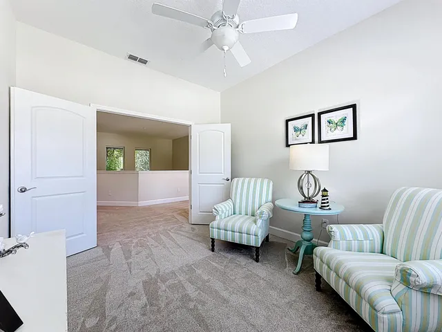 a living room with furniture and a view of kitchen