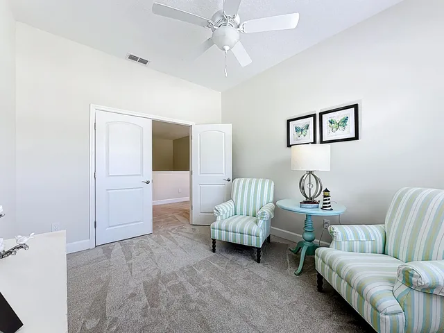 a living room with furniture and a ceiling fan