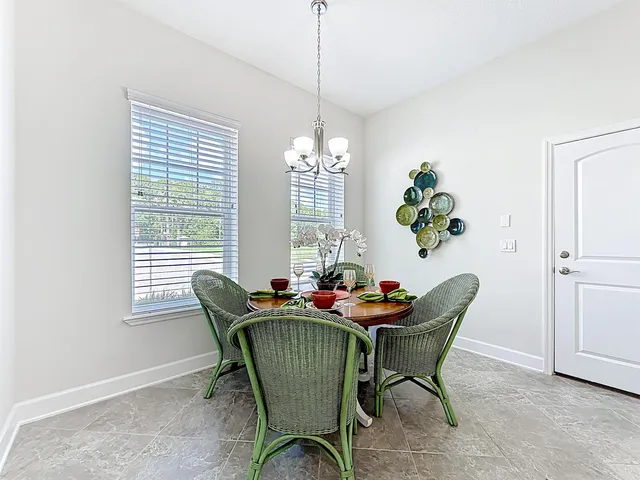 a dining room with furniture a potted plant and windows