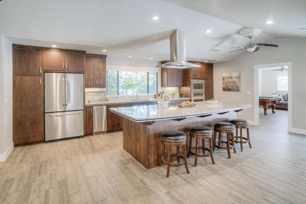 a kitchen with stainless steel appliances granite countertop a sink and a refrigerator